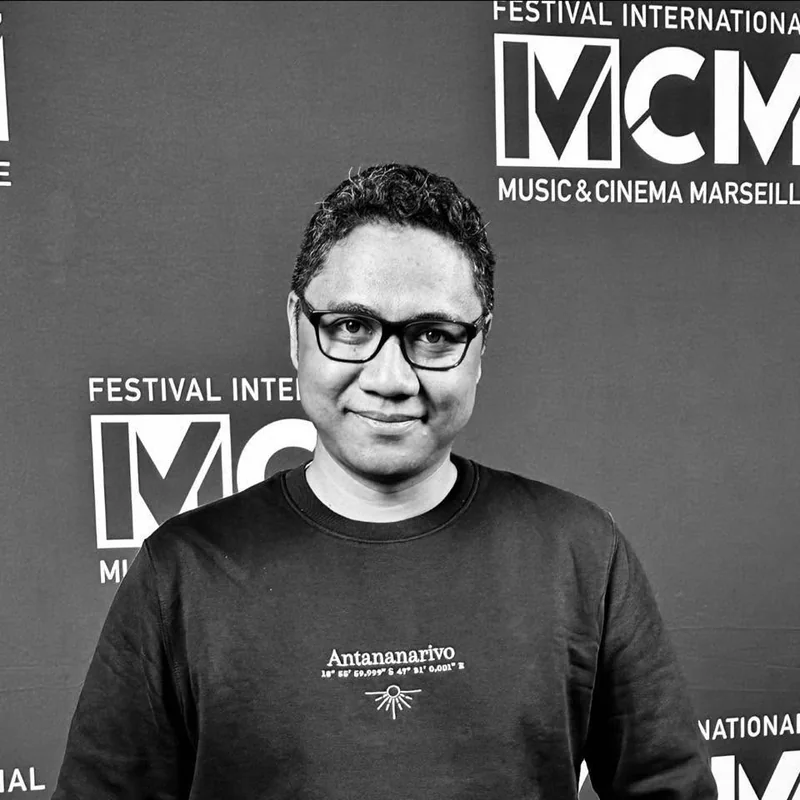 Rindra Ramili, portrait en noir et blanc, devant le mur du Festival International Music & Cinema Marseille.